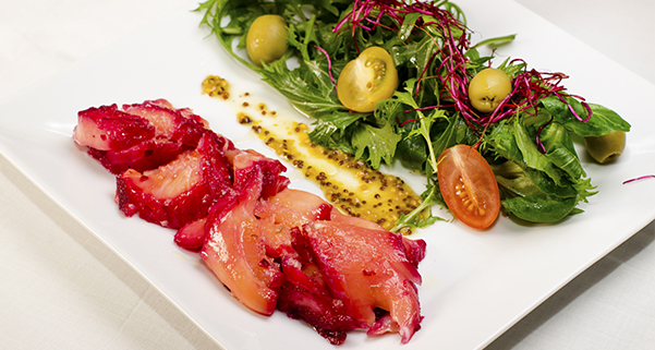 Salát z trhaných listů s olivami, cherry rajčaty, marinovaným  lososem v červené řepě a dresinkem z hrubozrnné hořčice